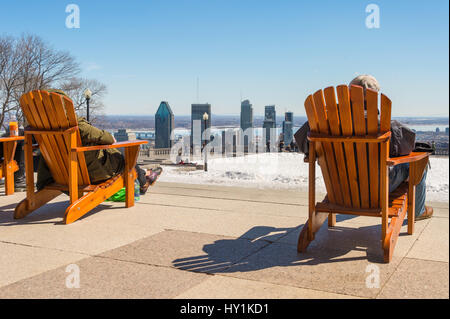 Montreal, CA - 30. März 2017: Menschen sitzen auf einem hölzernen Liegestuhl und genießen Sie einen sonnigen Frühlingstag auf Kondiaronk Belvedere Stockfoto