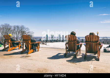 Montreal, CA - 30. März 2017: Menschen sitzen auf einem hölzernen Liegestuhl und genießen Sie einen sonnigen Frühlingstag auf Kondiaronk Belvedere Stockfoto