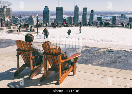 Montreal, CA - 30. März 2017: Menschen sitzen auf einem hölzernen Liegestuhl und genießen Sie einen sonnigen Frühlingstag auf Kondiaronk Belvedere Stockfoto