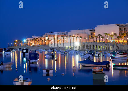 Die Abend-Blick auf die Wohnhäuser und Hotels Marsaskala zu reflektieren, im Wasser des Marsaskala Creek. Malta Stockfoto