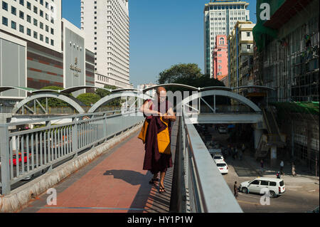 27.01.2017, Yangon, Republik der Union von Myanmar, Asien - A buddhistischen Mönch Traversen ein Fuß Brücke bei Sule Square im Zentrum von Yangon. Stockfoto