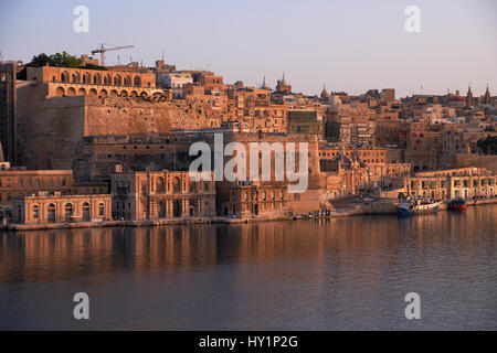 Die am frühen Morgen Blick auf Valletta Hauptstadt Befestigungsanlagen mit Fort Lascaris und Upper und Lower Barrakka Gardens aus dem Wasser des Grand Harbou Stockfoto