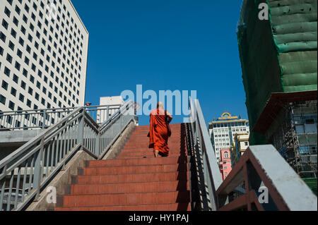 06.02.2017, Yangon, Republik der Union Myanmar, Asien - ein buddhistischer Mönch, der eine Fuß-Brücke an der sule Square im Zentrum von Yangon verfährt. Stockfoto