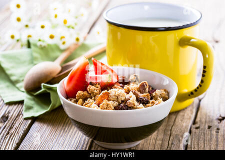 Hausgemachtem Müsli mit frischen Erdbeeren und Tasse Milch. Gesundes Frühstück Stockfoto