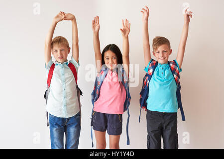 Drei glückliche Kinder Hände erhebend Stockfoto