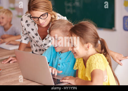 Lehrer mit Schülern mit Laptop im Klassenzimmer Stockfoto