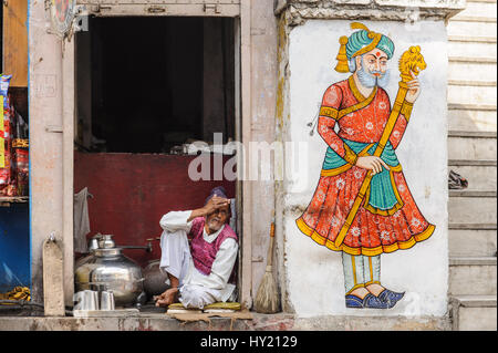 Chai Wallah in seinem Stall neben einer Rajput Wandmalerei in Udaipur Stockfoto