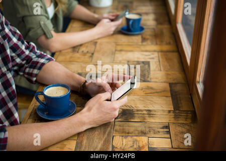 Bild von Mann und Frau, die Benutzung von Mobiltelefonen im Café beschnitten Stockfoto