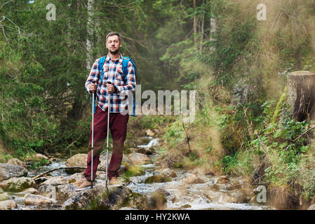 Junger Mann alleine in einem Wald wandern Stockfoto