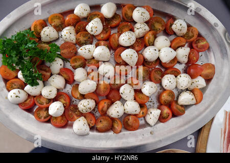 Mozzarella, Tomate und Basilikum auf weiße Platte angeordnet Stockfoto