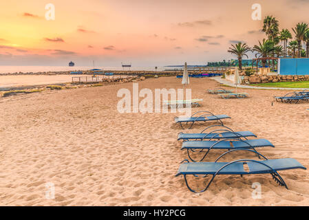 Sonnenuntergang am Strand in der Stadt von Paphos, Zypern. Blick auf das Mittelmeer und die Küste. Stockfoto