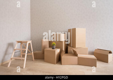 Kartons stapeln in neuen leeren Raum mit Trittleiter Stockfoto