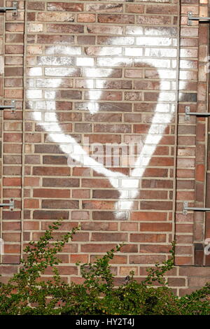 Sparaed weiße Herzen auf eine Mauer Stockfoto
