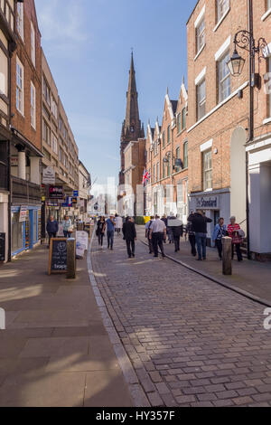 Chester City Shopper und Besucher auf Watergate Street mit seinen gepflasterten ebnen georgianischen Gebäuden und der Guildhall-Turm Stockfoto