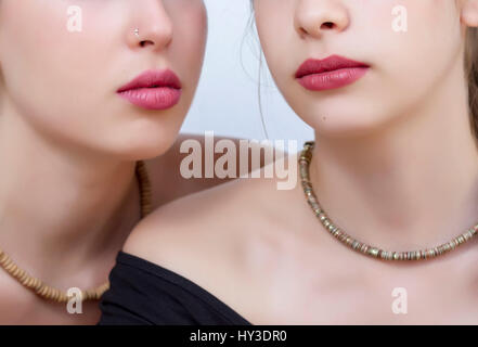 Nahaufnahme von zwei jungen Frauen Lippen auf weißem Hintergrund Stockfoto