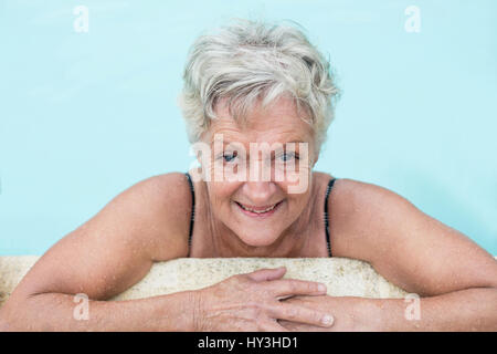 Porträt von senior Frau lehnt sich am Pool Stockfoto