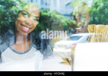 Porträt des jungen Brautpaares im Kaffeehaus durch Fenster gesehen Stockfoto