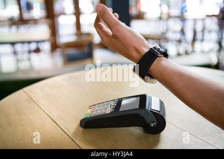 Beschnitten, Bild Mann Hand mit Smartwatch Pay in Coffee-Shop zum Ausdruck bringen Stockfoto