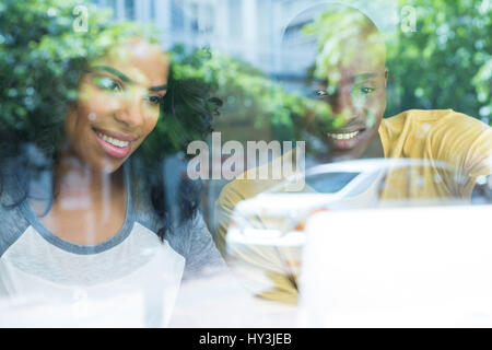 Lächelnd Multi ethnischen junges Paar im Café gesehen durch Fenster Stockfoto