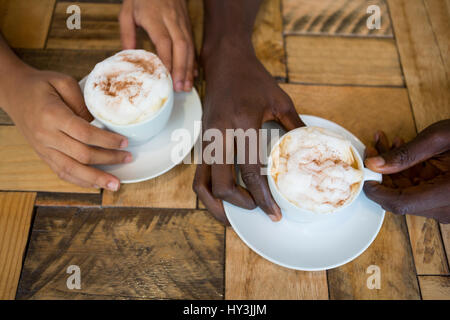 Hohen Winkel Nahaufnahme paar Hände halten Kaffeetassen im café Stockfoto