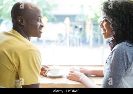 Junges Liebespaar sahen einander an Tisch im Kaffeehaus Stockfoto