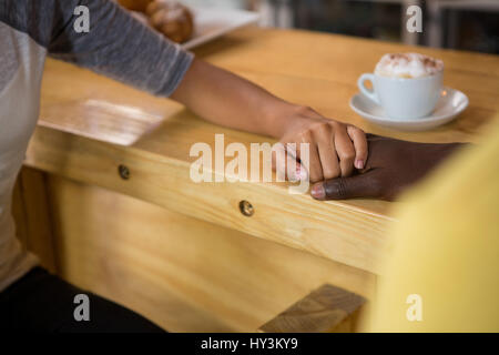 Bild des Multi-ethnischen paar Hand in Hand im Kaffeehaus beschnitten Stockfoto