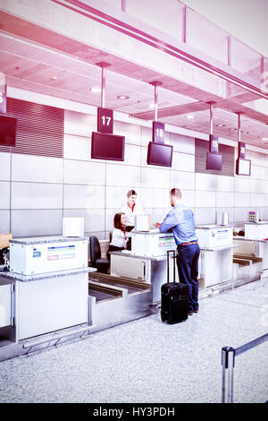 Mann am Ticketschalter im Flughafen Stockfoto