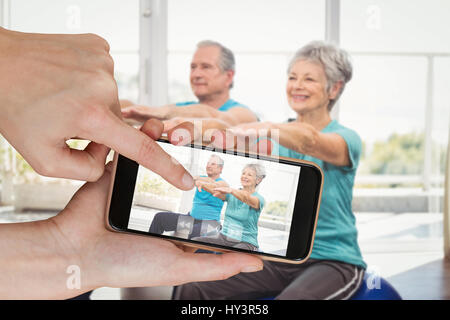 Hände berühren Smartphone gegen senior Brautpaar Übung Stockfoto