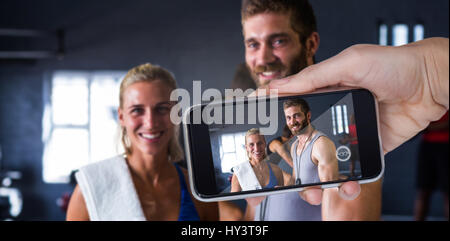Zusammengesetztes Bild von Hand halten Handys vor weißem Hintergrund Stockfoto