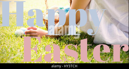 Kleines Mädchen sammeln Ostereier gegen happy Easter-logo Stockfoto