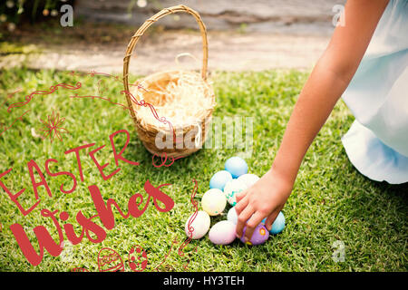 Kleines Mädchen sammeln Ostereier gegen glücklich Ostern rote Logo auf weißem Hintergrund Stockfoto