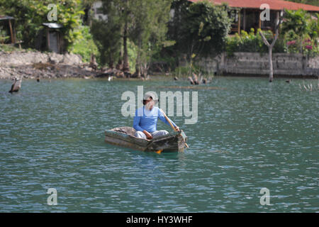 Fischer auf seine eigene Handarbeit gebaut Holzboot in See Lake Atitlan, Guatemala Stockfoto