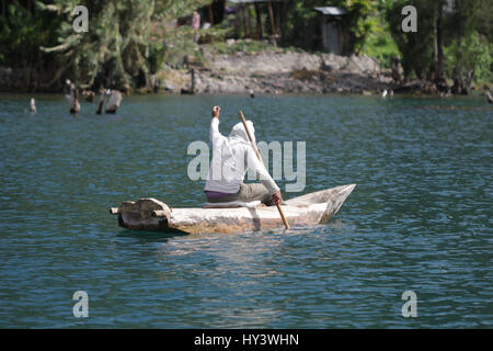 Fischer auf seine eigene Handarbeit gebaut Holzboot in See Lake Atitlan, Guatemala Stockfoto