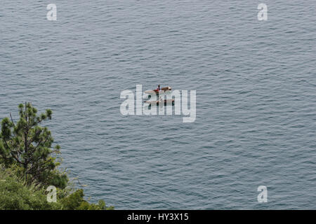 Fischer auf seine eigene Handarbeit gebaut Holzboot in See Lake Atitlan, Guatemala Stockfoto