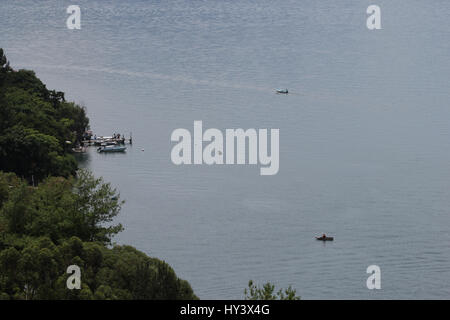 Fischer auf seine eigene Handarbeit gebaut Holzboot in See Lake Atitlan, Guatemala Stockfoto