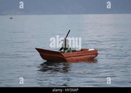 Fischer auf seine eigene Handarbeit gebaut Holzboot in See Lake Atitlan, Guatemala Stockfoto