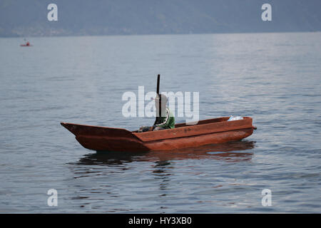 Fischer auf seine eigene Handarbeit gebaut Holzboot in See Lake Atitlan, Guatemala Stockfoto