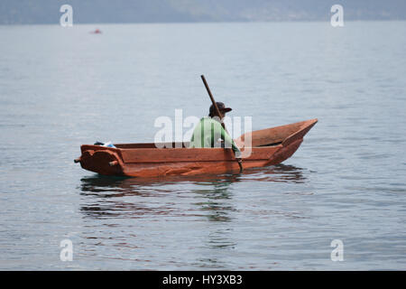 Fischer auf seine eigene Handarbeit gebaut Holzboot in See Lake Atitlan, Guatemala Stockfoto