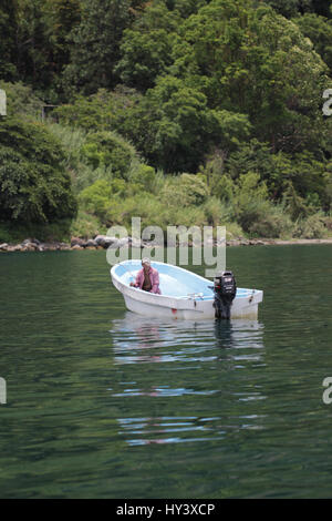 Fischer auf seine eigene Handarbeit gebaut Holzboot in See Lake Atitlan, Guatemala Stockfoto