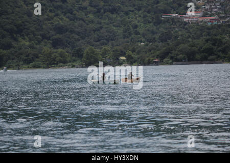 Fischer auf seine eigene Handarbeit gebaut Holzboot in See Lake Atitlan, Guatemala Stockfoto