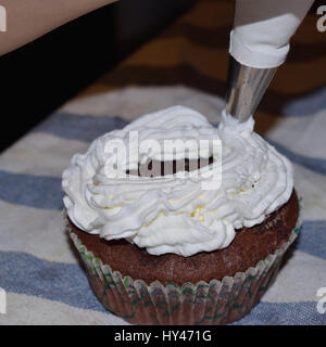 Tasse Kuchen mit Sahne und verschiedene bunte Dekorationen Stockfoto