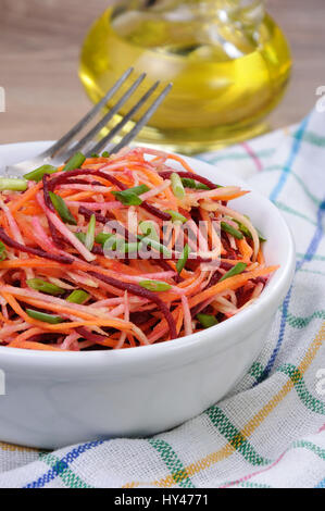 eine Schüssel Salat aus geriebenen rohen Rüben und Karotten auf Sellerie Stockfoto