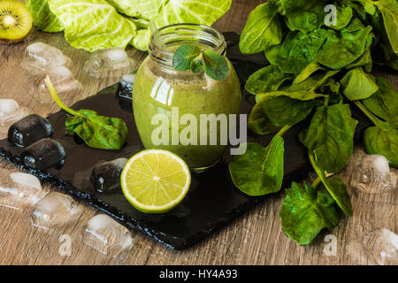 Detox-Diät. Grüner Smoothie mit Obst und Gemüse auf hölzernen dunklen Hintergrund. Stockfoto