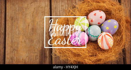 Frohe Ostern gegen bemalte Ostereier im nest Stockfoto