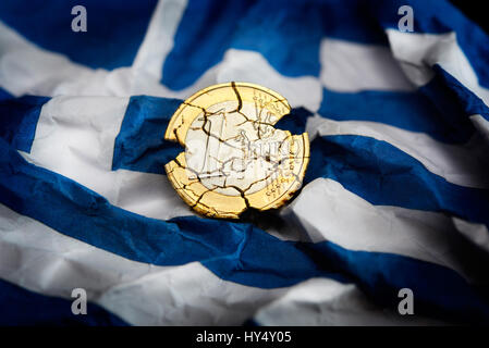 EuroCoin mit Tränen auf zerknitterten Griechenland Flagge, symbolische Foto Schulden Quarrel, Euromuenze Mit Rissen Auf Zerknitterter Griechenlandfahne, Symbolfoto Schuld Stockfoto