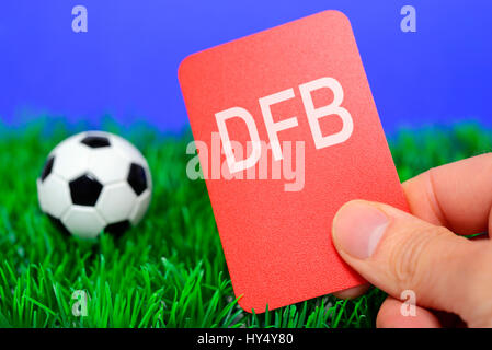 Miniatur-Fußball und Hand mit roten Karte, DFB-Skandal, Miniaturfu? ball Und Hand Mit Roter Karte, DFB-Skandal Stockfoto