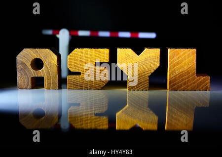 Das Wort Asyl aus Holz schreiben und Mautstelle, obere Grenze für Flüchtlinge, Das Wort Asyl aus Holzbuchstaben Und Schlagbaum, Obergrenze Fuer Fluechtlin Stockfoto