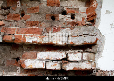 Vintage Hintergrundtextur von alten Ziegel Mauerwerk auf alten Zement mit Rissen mit Spuren von alten Farbe. Stockfoto