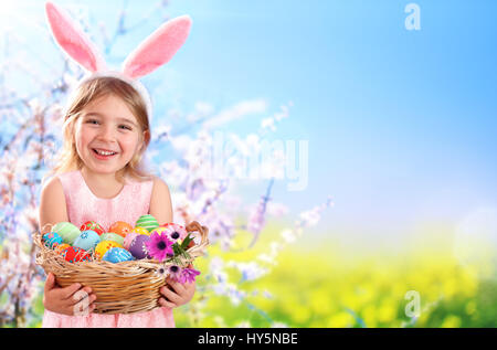 Ostern - kleines Mädchen mit Korb Eiern und Hasenohren Stockfoto