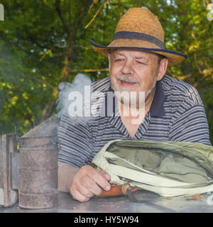 Outdoor Portrait von positiven älterer Mann Imker tragen Stroh Hut Stockfoto